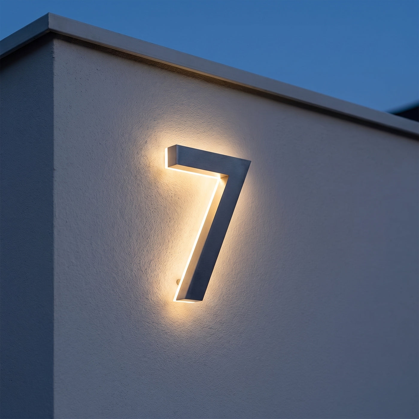 Cyfra LED ze stali nierdzewnej z ciepłą poświatą halo na ścianie o zmierzchu