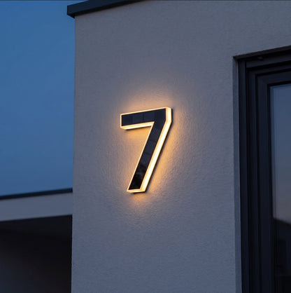 Cyfra solarna LED świecąca ciepłym światłem na elewacji o zmierzchu
