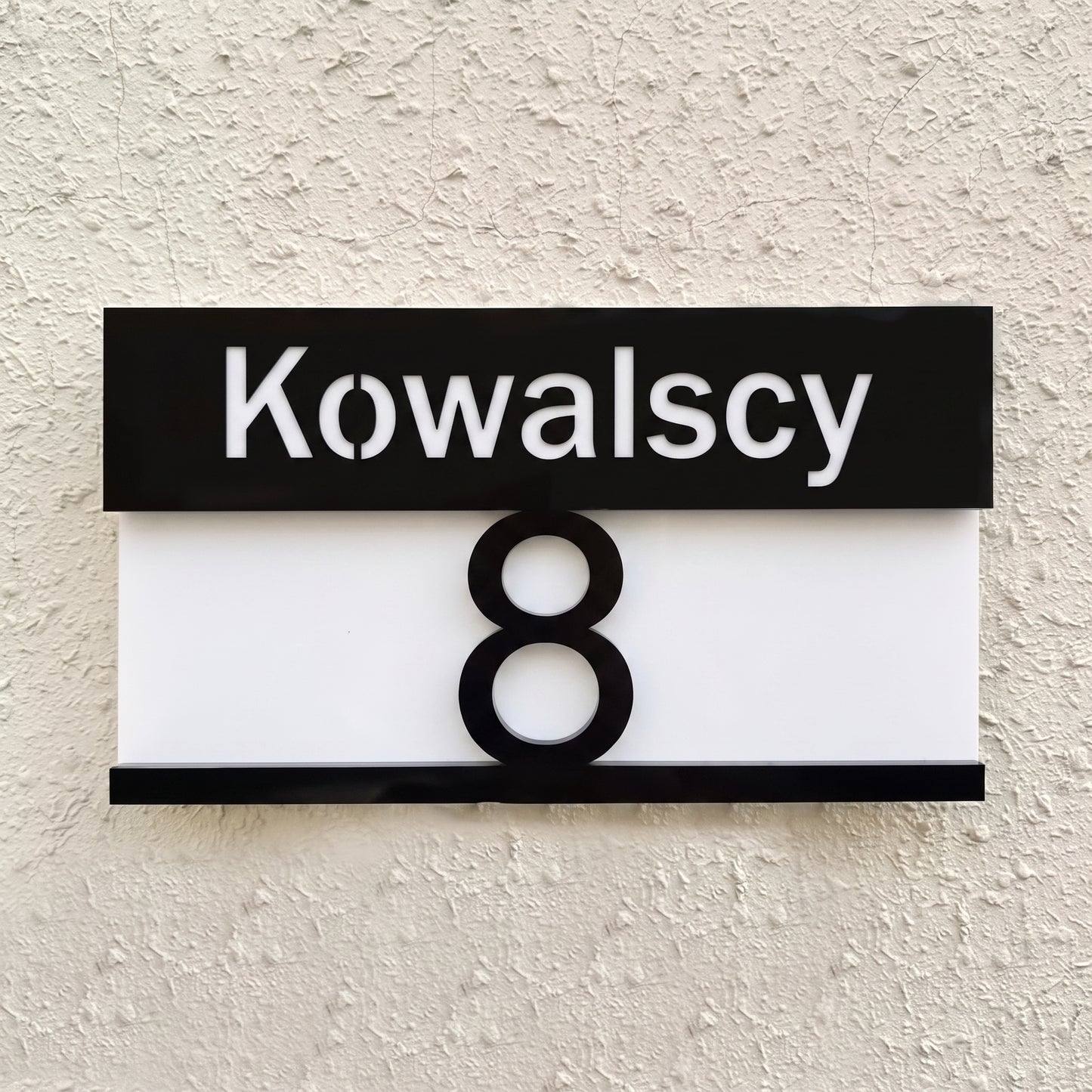 Tabliczka pozioma 28×16 — widok z przodu, czarny pas z nazwiskiem Kowalscy i numer 8