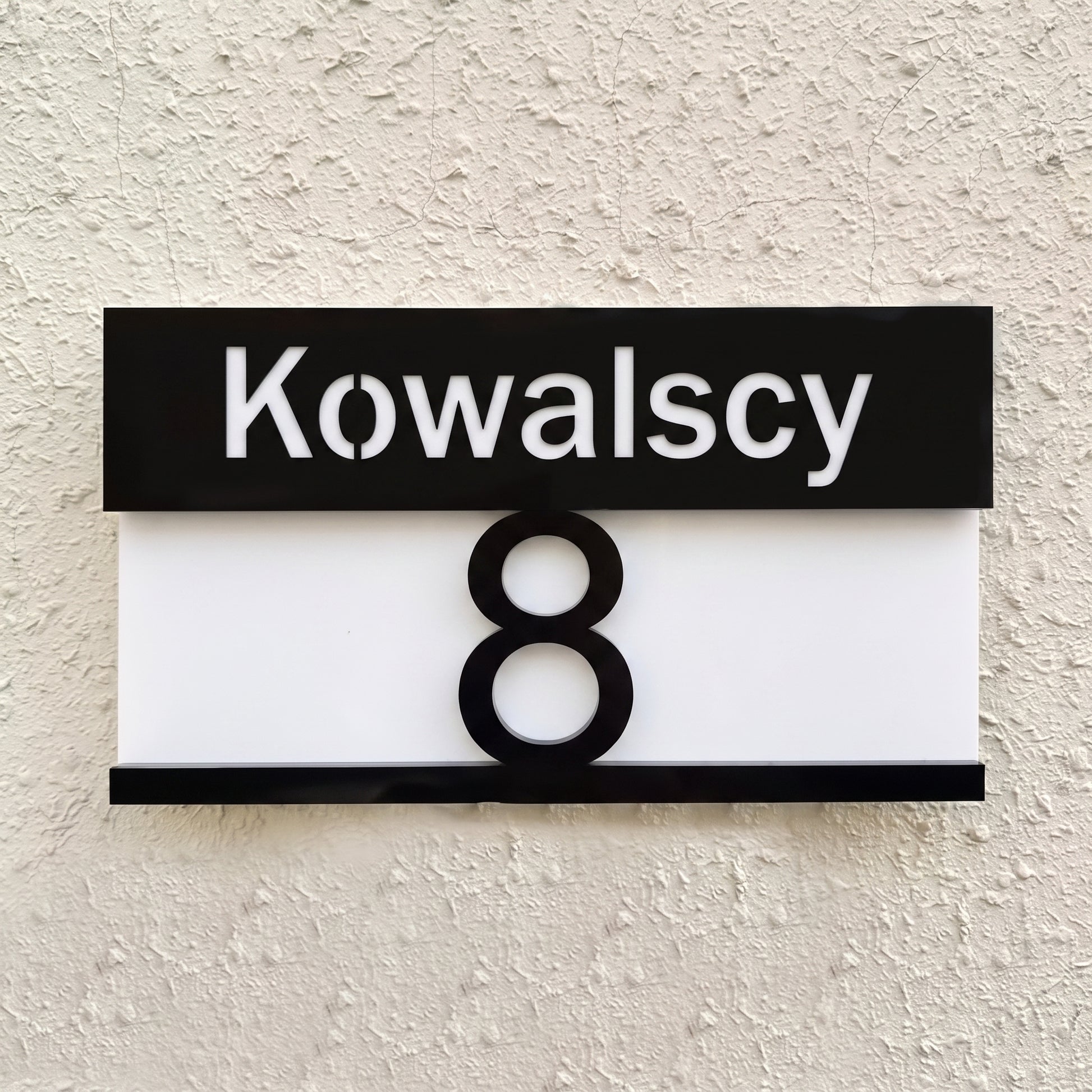 Tabliczka pozioma 28×16 — widok z przodu, czarny pas z nazwiskiem Kowalscy i numer 8