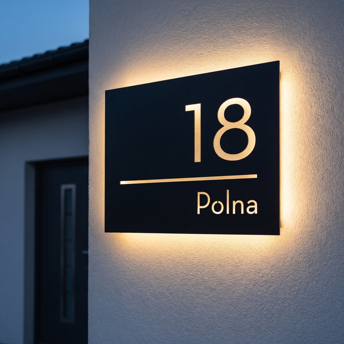 Podświetlana tabliczka adresowa LED 18 Polna z ciepłą poświatą halo na jasnoszarej elewacji o niebieskiej godzinie