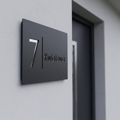 Grawerowana tabliczka adresowa z numerem 7 i nazwą ulicy Kwiatowa na elewacji domu