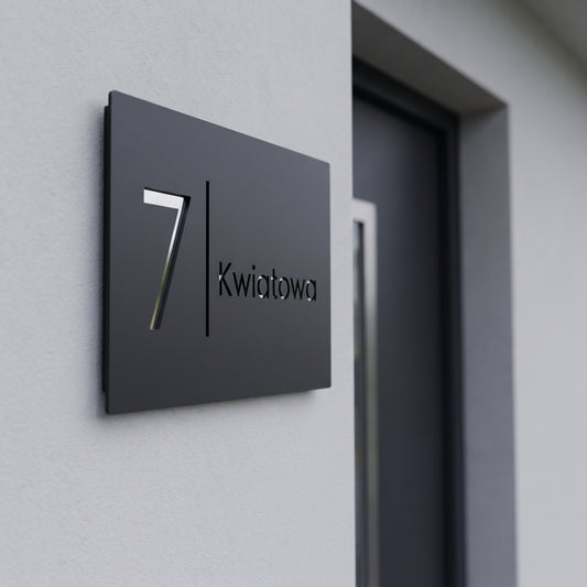 Grawerowana tabliczka adresowa z numerem 7 i nazwą ulicy Kwiatowa na elewacji domu