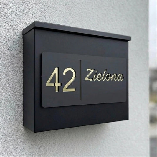 Tabliczka adresowa na czarnej skrzynce pocztowej — numer 42 i nazwa ulicy Zielona w złocie